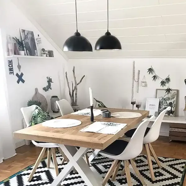 Lustre 2 lampes avec finition noir et doré suspendues au-dessus d'une table dans une salle à manger